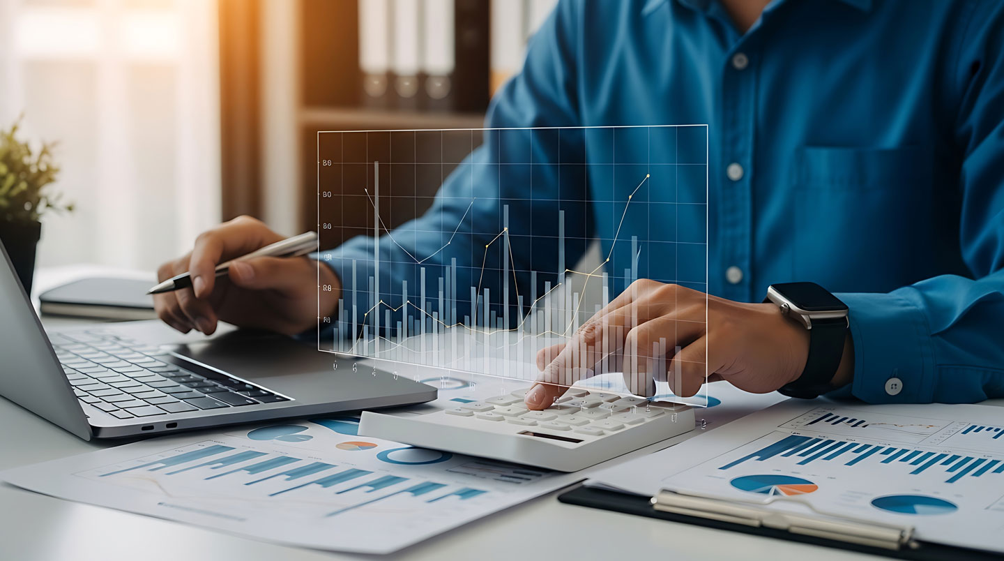 Vue de dessus d'un bureau montrant un graphique imprimé d'évolution de chiffre d'affaires avec courbe ascendante approchant une ligne rouge de seuil réglementaire, accompagné d'un tableur Excel, calculatrice et mains pointant les données